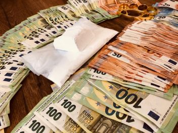 Detailaufnahme von Suchtmittel und gestückeltem Bargeld