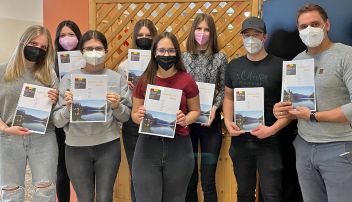 Stolz präsentieren Leni Kieler, Katharina Petter, Antonia Josipovic, Carina Seethaler, Eszter Babics, Sabrina Piller und Jakob Gasperl mit Fachvorstand Moser ihr Kochbuch