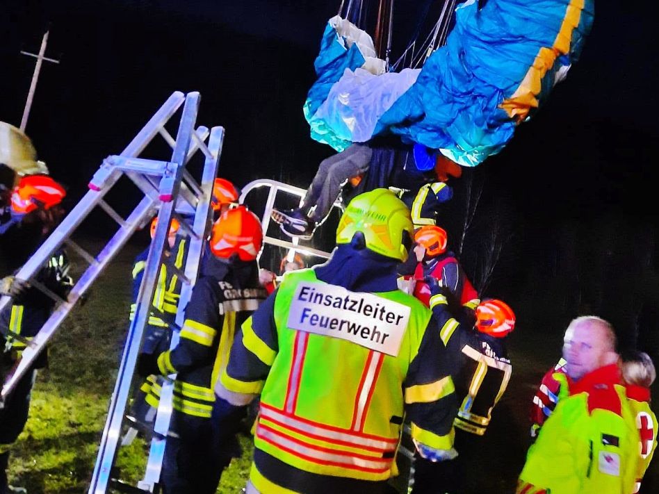 Paragleiter hängt in einer Hochspannungsleitung
