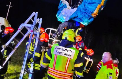 Paragleiter hängt in einer Hochspannungsleitung